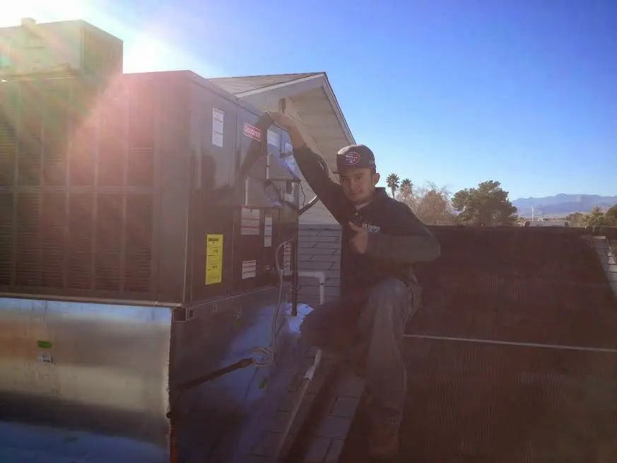 HVAC technician performing Heat Pump Repair on a rooftop unit in Piedmont
